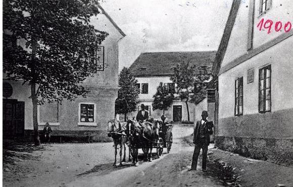  Fotografie z r. 1900 p�edstavuje starou �kolu, kter� se nach�zela uprost�ed obce na n�m�st� u silnice (budova uprost�ed).